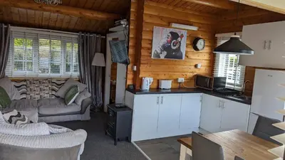 a kitchen and living room in a log cabin at Snowdonia Log cabin in Trawsfynydd