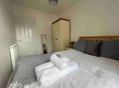 a bedroom with a bed with towels on it at Modern 2 BR Flat in Town Centre in Aberystwyth