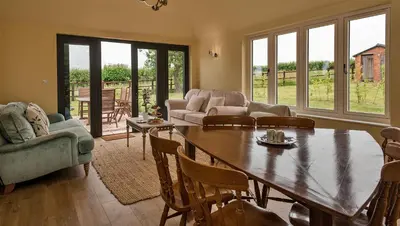 a living room with a wooden table and chairs at Finest Retreats - Fox and Hare in Shrawardine
