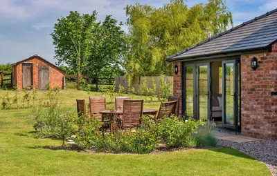 a patio with chairs and a table in a garden at Finest Retreats - Fox and Hare in Shrawardine