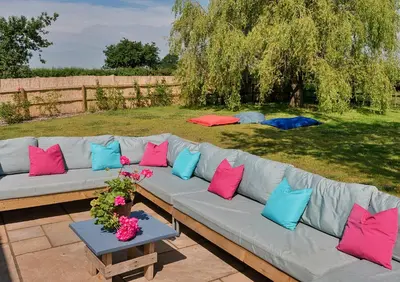 a couch with colorful pillows sitting on a patio at Finest Retreats - Fox and Hare in Shrawardine