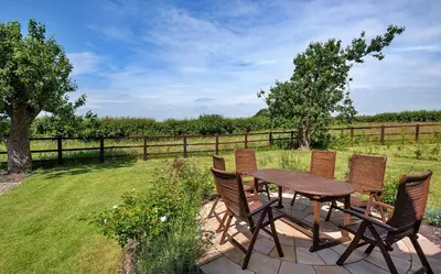 a wooden table and chairs on a patio at Finest Retreats - Fox and Hare in Shrawardine