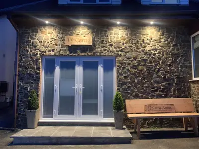 a building with a door and a bench in front of it at Ty Cerrig seaside Annexe, New Quay in New Quay