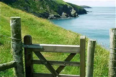 a wooden gate on a hill near the ocean at Ty Cerrig seaside Annexe, New Quay in New Quay