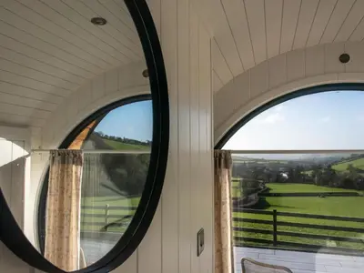 a round window in a house with a view of a golf course at Ceunant in Aberystwyth