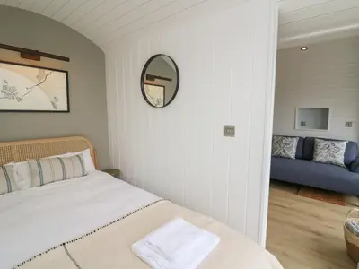 a bedroom with a bed and a mirror at Ceunant in Aberystwyth