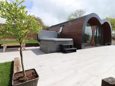 a garden with a hot tub and a tree at Creuddyn in Aberystwyth