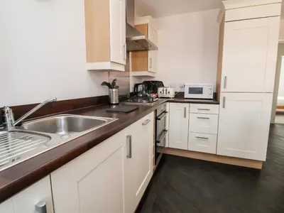 a kitchen with white cabinets and a stainless steel sink at 122 The Old Meadow in Shrewsbury