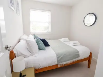 a white bedroom with a bed and a window at 122 The Old Meadow in Shrewsbury