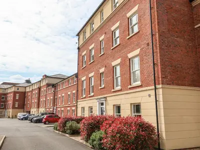a row of brick buildings with cars parked on a street at 122 The Old Meadow in Shrewsbury