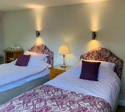 two beds sitting next to each other in a room at Sayang House in Church Stretton