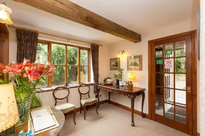 a home office with a desk and chairs and windows at Sayang House in Church Stretton