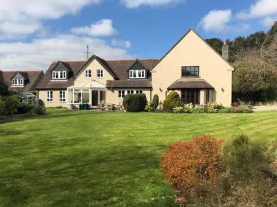 a large white house with a large yard at Sayang House in Church Stretton