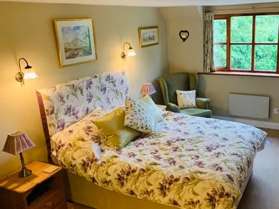 a bedroom with a bed and a chair at Sayang House in Church Stretton