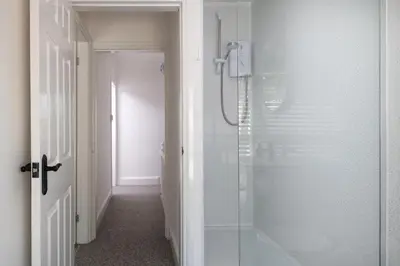 a bathroom with a shower with a glass shower stall at Bron Eryri - Our Cosy House opposite the entrance to Portmeirion! in Mynfford