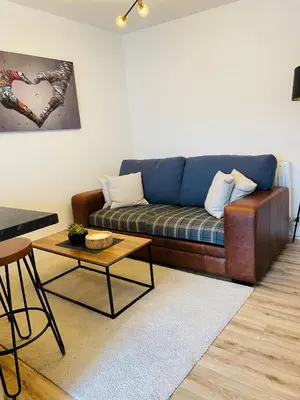 a living room with a blue couch and a table at Flat 1 in Lampeter