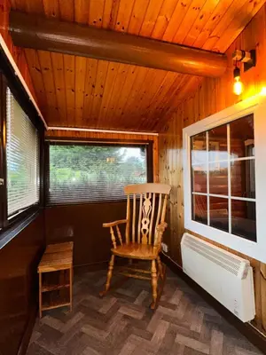 a rocking chair in a room with a window at Snowdonia Escape in Trawsfynydd