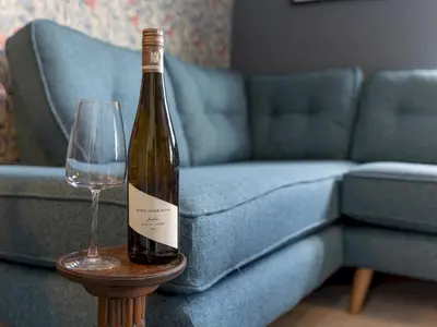 a bottle of wine sitting on a table next to a couch at The William Morris Lodge in the centre of Ludlow - Pass the Keys in Ludlow