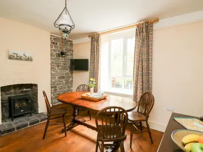 a dining room with a table and chairs and a fireplace at Myrtle Villa in Knighton