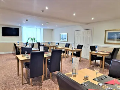 a conference room with wooden tables and chairs at Richmond Hotel in Aberystwyth