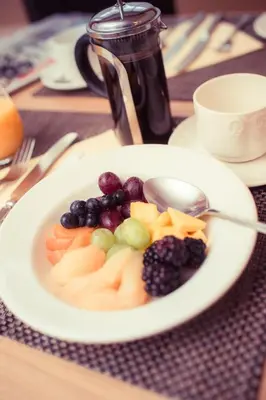 a white plate of fruit on a table at Richmond Hotel in Aberystwyth