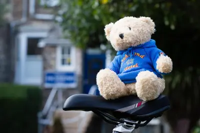 a teddy bear sitting on the seat of a bike at Richmond Hotel in Aberystwyth
