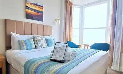 a bedroom with a bed with a laptop on it at Richmond Hotel in Aberystwyth