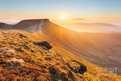 a view of a hill with the sun setting on it at Ty Hobi Bach - at the foot of the Black Mountains in Brecon