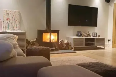 a living room with a fireplace and a tv at Ty Hobi Bach - at the foot of the Black Mountains in Brecon