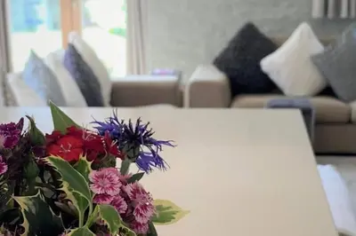 a white table with a bouquet of flowers on it at Ty Hobi Bach - at the foot of the Black Mountains in Brecon