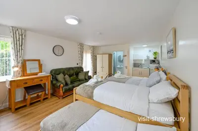 a bedroom with a bed and a living room at Personal En-suite in Shrewsbury