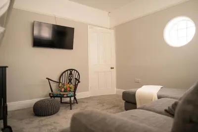 a living room with a couch and a tv on the wall at Rose Hill in Shrewsbury