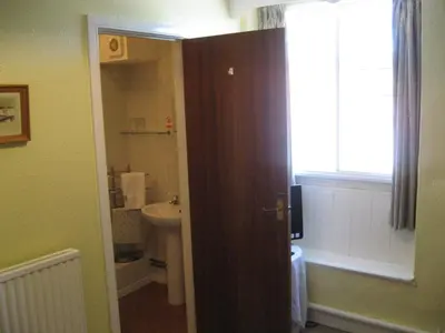 a bathroom with a sink and a toilet and a window at The Red Lion Hotel in Bredwardine