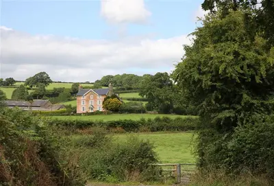 a large house in the middle of a field at Upper Mowley in Kington