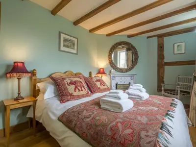 a bedroom with a bed with towels on it at Bearwood House & Cottage in Pembridge
