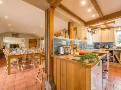 a kitchen with a table and a counter top at Bearwood House & Cottage in Pembridge