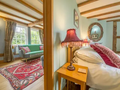 a bedroom with a bed and a table with a lamp at Bearwood House in Pembridge