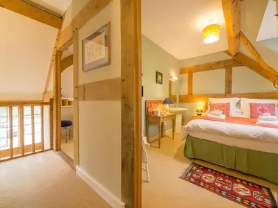 a bedroom with a large bed in a room at Bearwood Cottage in Pembridge