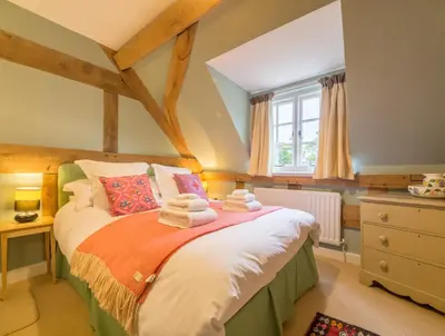 a bedroom with a bed with towels on it at Bearwood Cottage in Pembridge