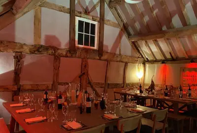 a dining room with tables with wine bottles and chairs at Bearwood Cottage in Pembridge
