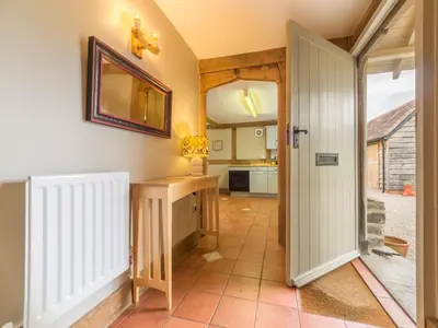 a hallway with a door open to a kitchen at Bearwood Cottage in Pembridge