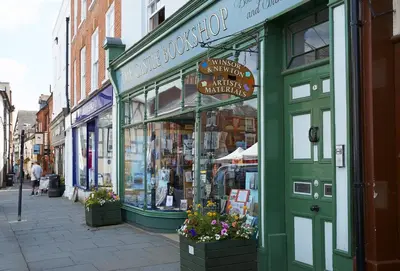 a green storefront of a book store on a street at Wassell Barn in Craven Arms