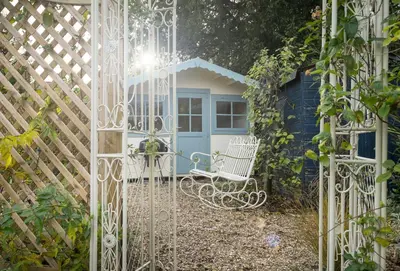 a gate leading into a garden with a shed at Cobbler's Cottage in Pembridge
