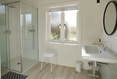 a white bathroom with a shower and a sink at Green Gables in Eardisley