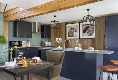 a kitchen with blue cabinets and a table with food on it at The Timber Barn in Downton