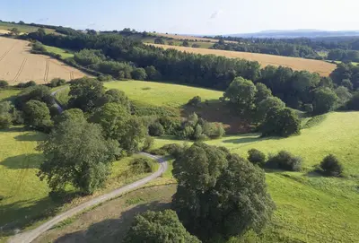 an aerial view of a road in a field with trees at The Stone Barn in Downton