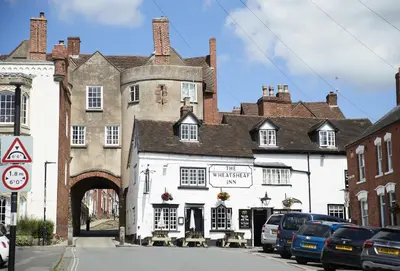 an old building on a street with cars parked outside at The Stone Barn in Downton