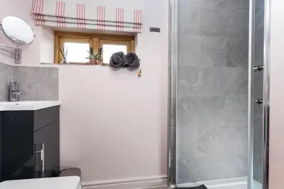 a bathroom with a shower and a toilet and a sink at Stone House in Leominster