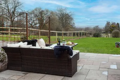 a wicker couch sitting on a patio at Stone House in Leominster