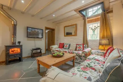 a living room with two couches and a wood stove at The Garden Barn in Peterchurch